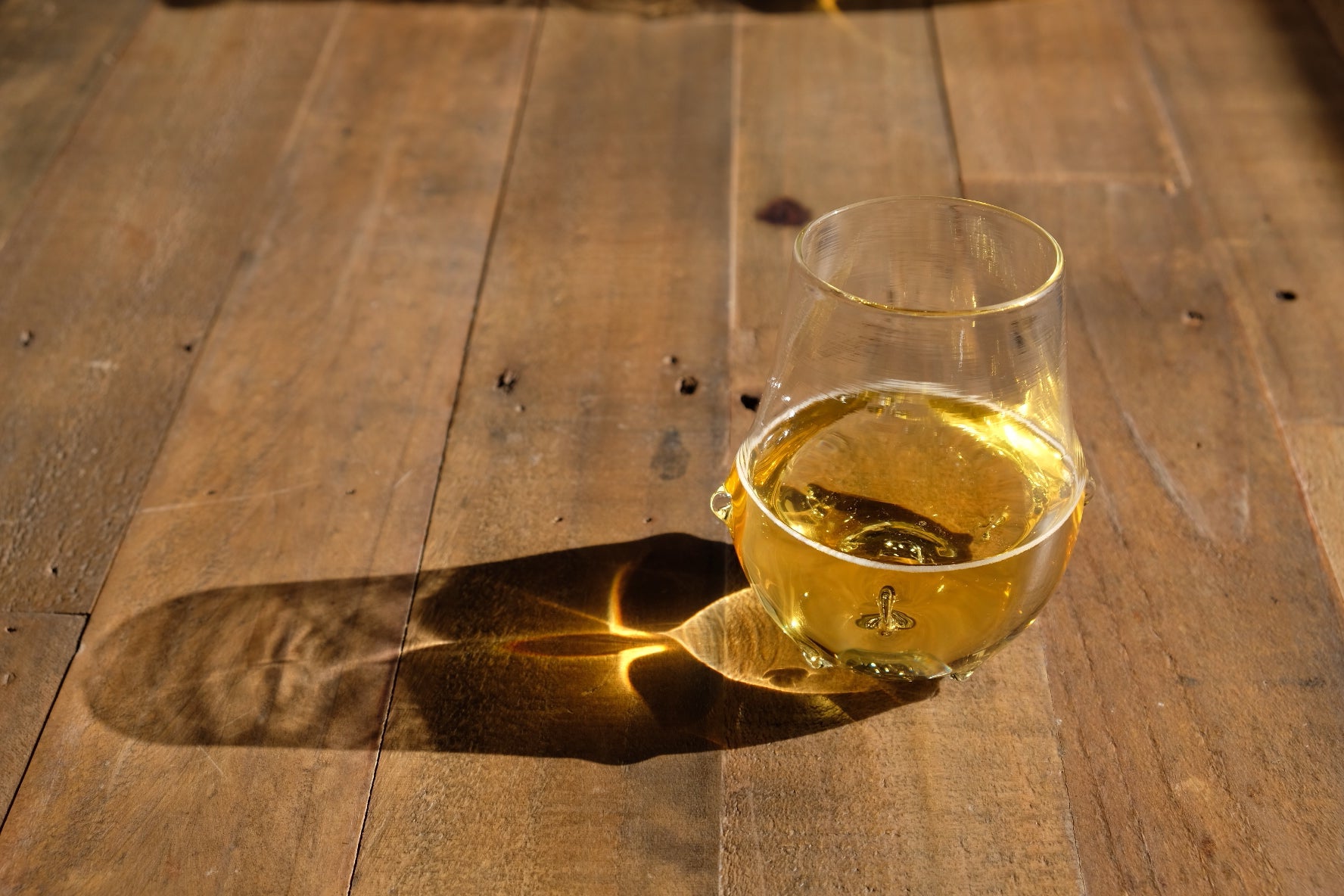 Glass of yellow liquid on a wooden surface